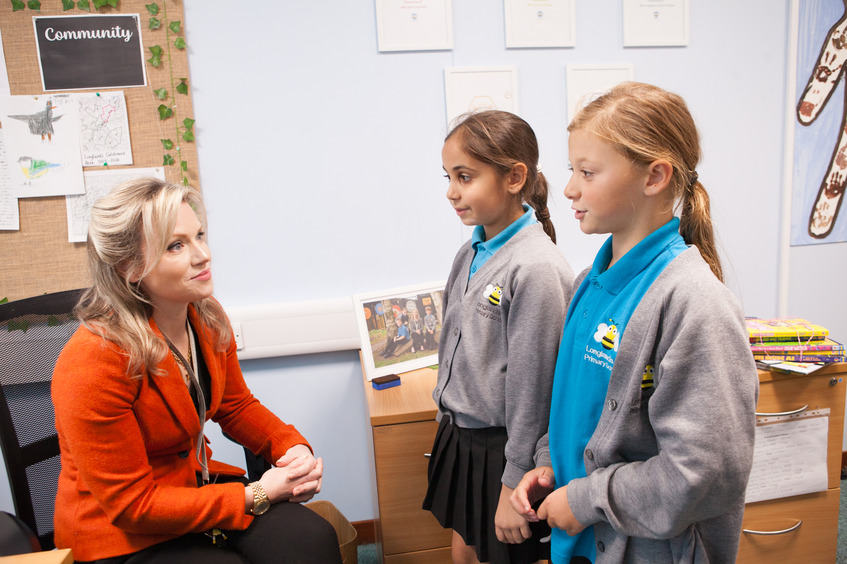 Two Longlands pupils talking with a member of staff.