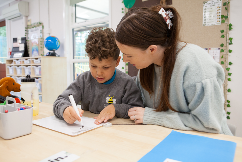 A Longlands pupil completing work with support from a member of staff.